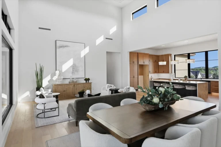 Dining area with a long wood table open to the kitchen and living room of a Boerne custom home