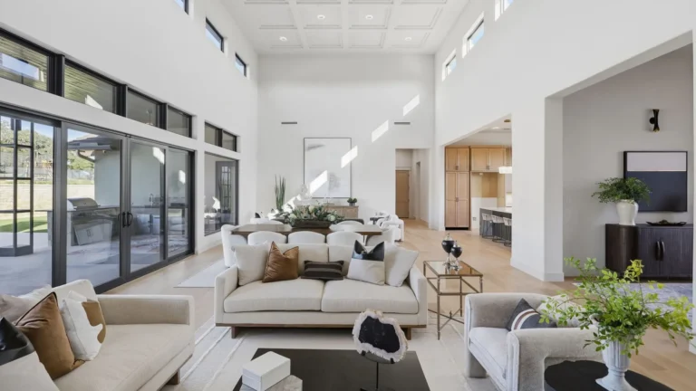 Great room with walls of sliding glass opening to the covered patio in a Boerne, TX custom home