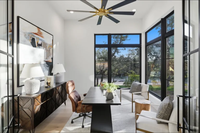Home office with black steel windows, oak views and a modern desk in a Boerne, TX custom home