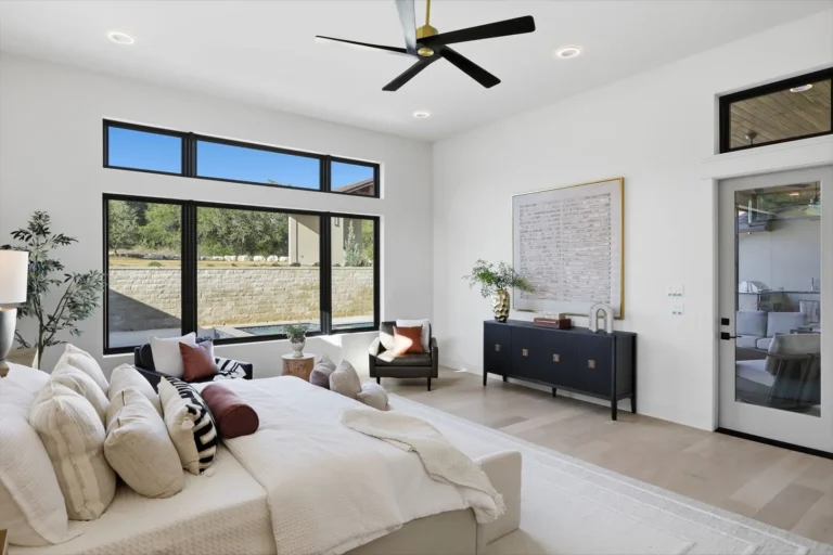 Primary suite with picture windows and a door to the covered patio in a Boerne custom home