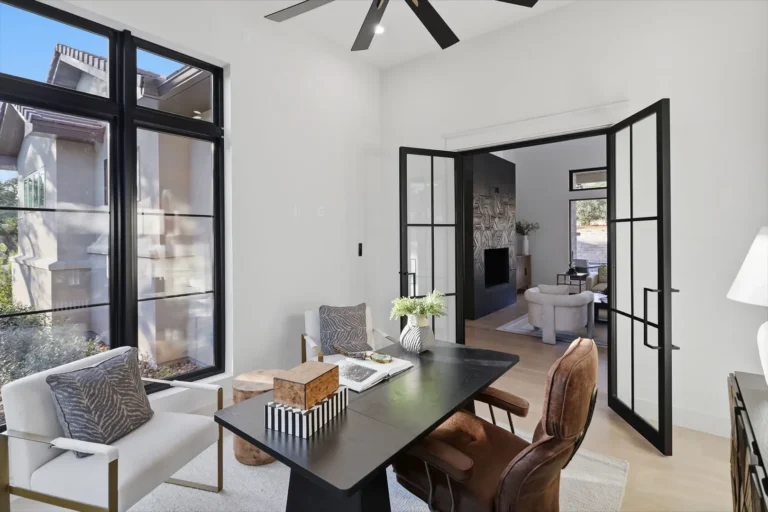 Study with steel-and-glass French doors opening to the great room of a Boerne luxury custom home