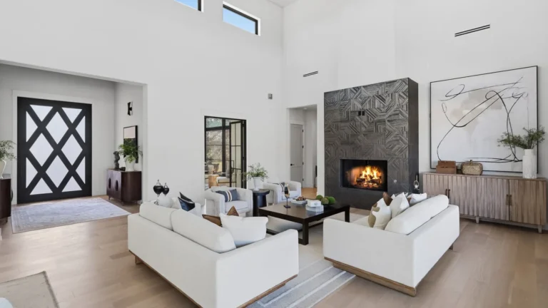 Great room with a geometric tile fireplace, diamond-pattern front door and tall clerestory windows in a Boerne, TX custom home