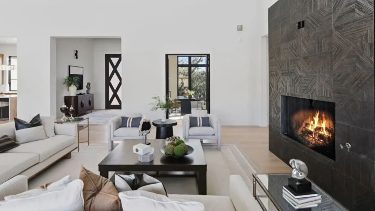 Living room in a Boerne, TX luxury custom home with a dark geometric tile fireplace and black steel doors