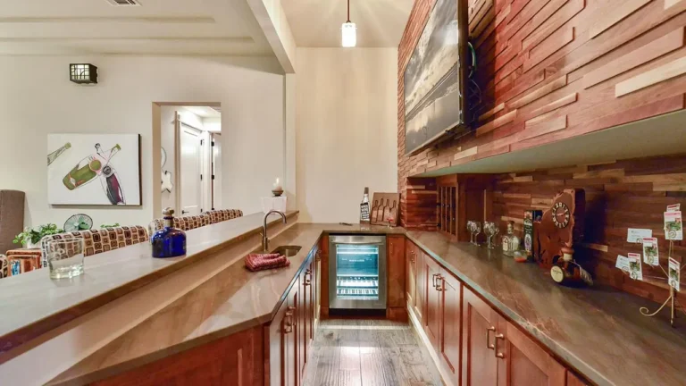 Wet bar with a mixed-tone wood plank wall, beverage refrigerator and long counter