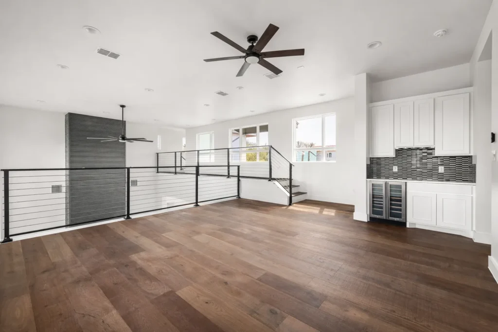 Upstairs game room with a wet bar, wine fridge, cable railing and wide-plank hardwood floors