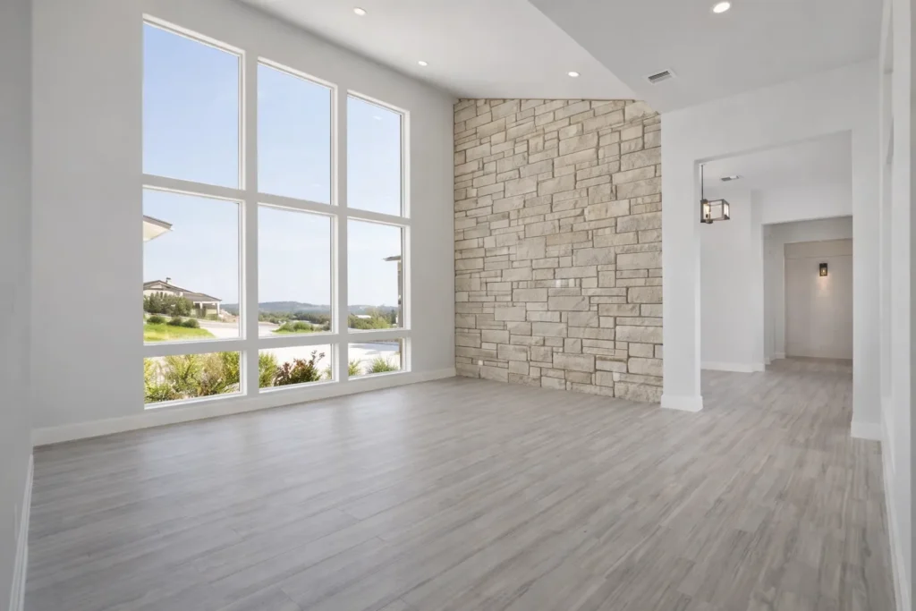 Living room with floor-to-ceiling windows and a limestone accent wall