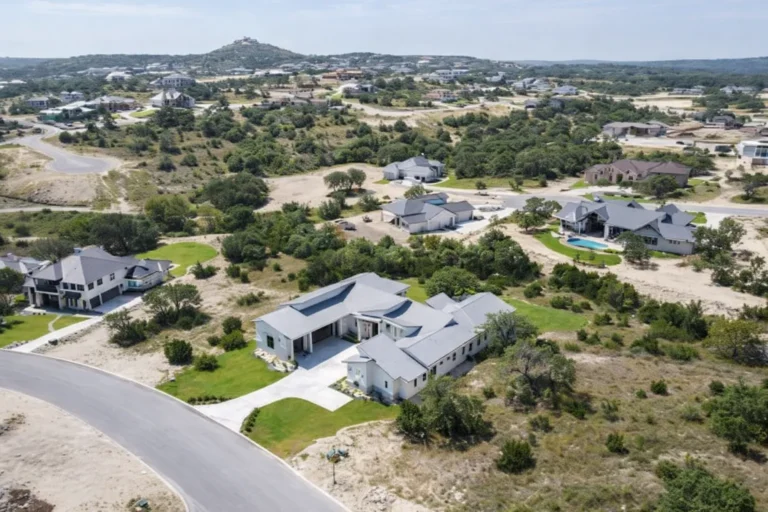 Aerial view of a single-story modern custom home in a new Texas Hill Country community with distant hills