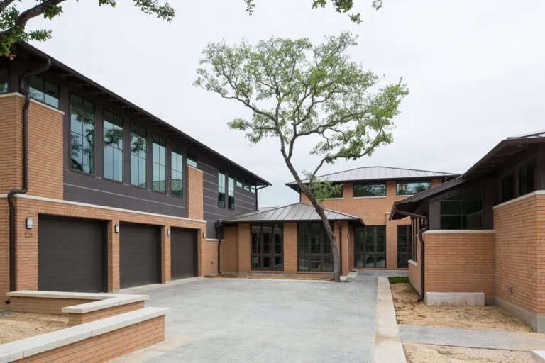 Prairie-modern custom home with brick and dark siding, clerestory windows and a three-car motor court in North San Antonio