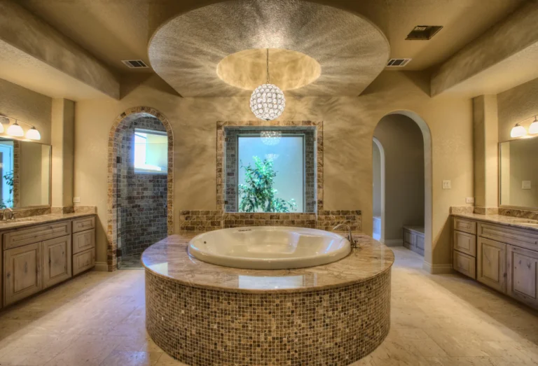 Primary bath with a round mosaic-tile soaking tub beneath a domed ceiling and crystal chandelier in Terra Mont, San Antonio